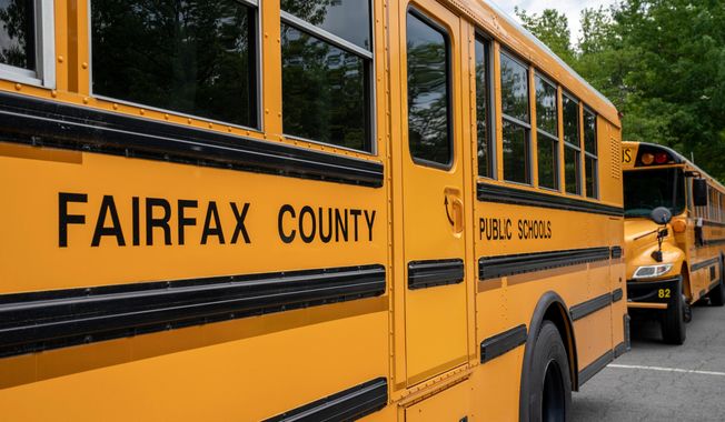 FILE - Fairfax County Public School buses idle at a middle school in Falls Church, Va., July 20, 2020. (AP Photo/J. Scott Applewhite, File)