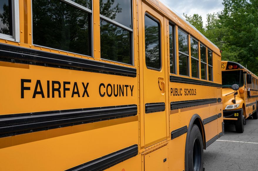 FILE - Fairfax County Public School buses idle at a middle school in Falls Church, Va., July 20, 2020. (AP Photo/J. Scott Applewhite, File)