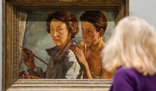 A woman looks at the artwork "I and my model" by artist Lotte Laserstein at the new exhibition "Queer Modernism. 1900 to 1950" at the Kunstsammlung NRW museum in Duesseldorf, Germany, highlighting the contributions of queer artists to modernism. (AP Photo/Martin Meissner)