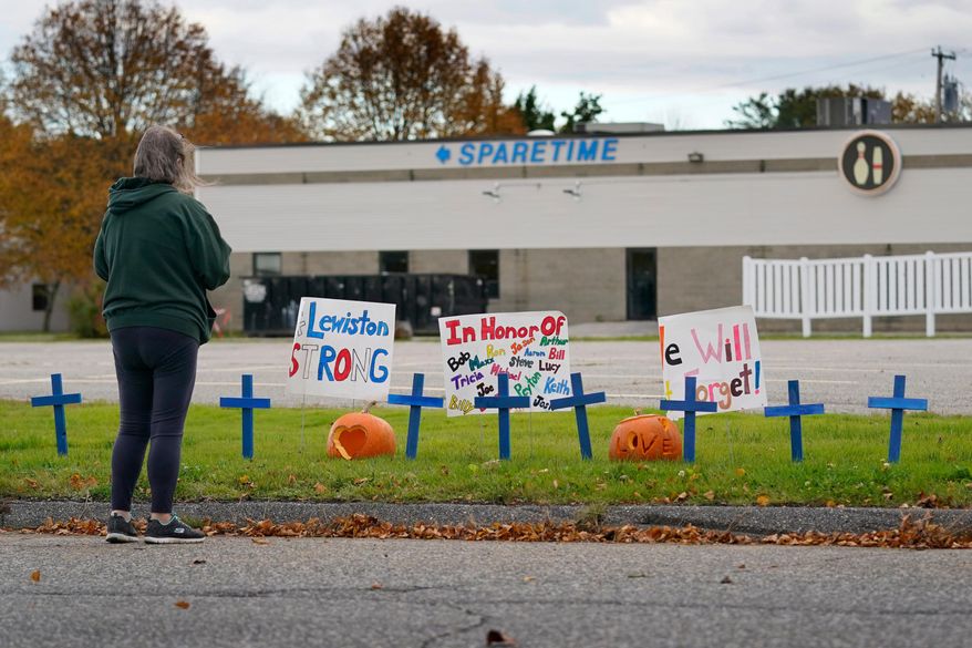 FILE - A woman visits a makeshift memorial outside Sparetime Bowling Alley, the site of a mass shooting, Oct. 28, 2023, in Lewiston, Maine. (AP Photo/Robert F. Bukaty, File)