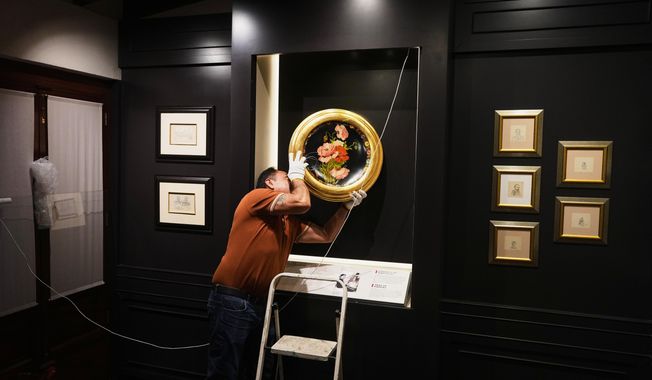 A curator hangs “A Tray of Poppies”, one of Frida Kahlo’s first works that she painted as gift for her Aunt Ana, in preparation for the opening of the new museum Casa Kahlo, a house bought by Kahlo’s father after he gave the iconic Casa Azul to his daughter as a wedding gift, in Mexico City, Wednesday, Sept. 10, 2025. (AP Photo/Eduardo Verdugo)