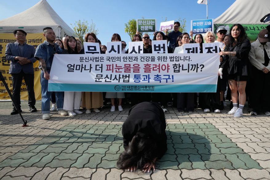 Lim Bo-ran, leader of the Korea Tattoo Federation, bows during a press conference demanding to the parliament the passing of a bill that would allow non-medical personnel to give tattoos outside the National Assembly in Seoul, South Korea, Thursday, Sept. 25, 2025, (AP Photo/Ahn Young-joon)