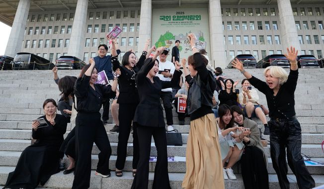 Members of the Korea Tattoo Federation celebrate after hearing the news that parliament passed a bill that would allow non-medical personnel to give tattoos outside the National Assembly, in Seoul, South Korea, Thursday, Sept. 25, 2025. (AP Photo/Ahn Young-joon)