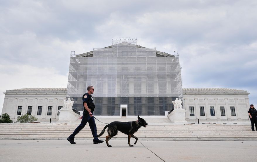 U.S. Capitol Police officers with a K9 detector dog, patrols outside of Supreme Court, Wednesday, Sept. 24, 2025, in Washington. (AP Photo/Mariam Zuhaib) ** FILE **