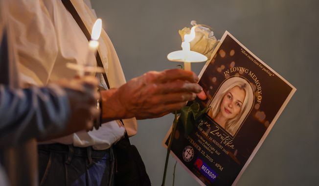 Community members hold candles as they gather for a vigil honoring the life of Iryna Zarutska, who was fatally stabbed on a commuter train last month, Monday, Sept. 22, 2025, in Charlotte, N.C. (AP Photo/Nell Redmond)