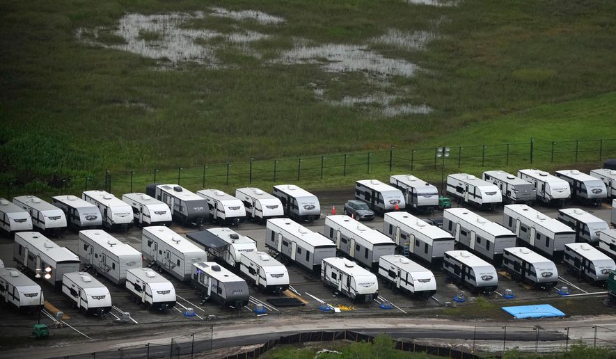 FILE - Trailers sit parked in lines as work progresses on a migrant detention center at Dade-Collier Training and Transition facility in the Florida Everglades, July 4, 2025, in Ochopee, Fla. (AP Photo/Rebecca Blackwell, file)