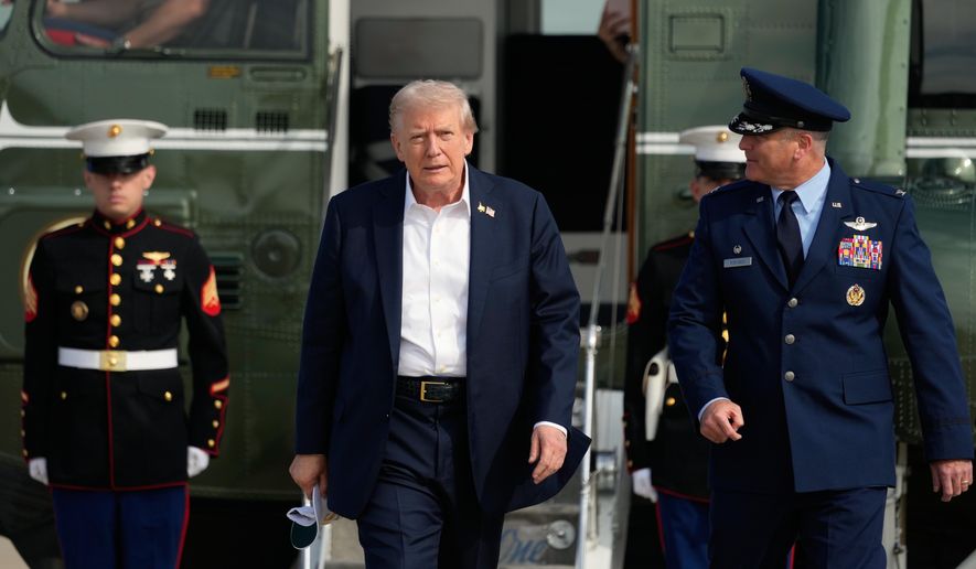 President Donald Trump, center, is escorted by Air Force Col. Christopher M. Robinson, commander of the 89th Airlift Wing, right, as he walks from Marine One to board Air Force One, Friday, Sept. 26, 2025, at Joint Base Andrews, Md. (AP Photo/Alex Brandon)