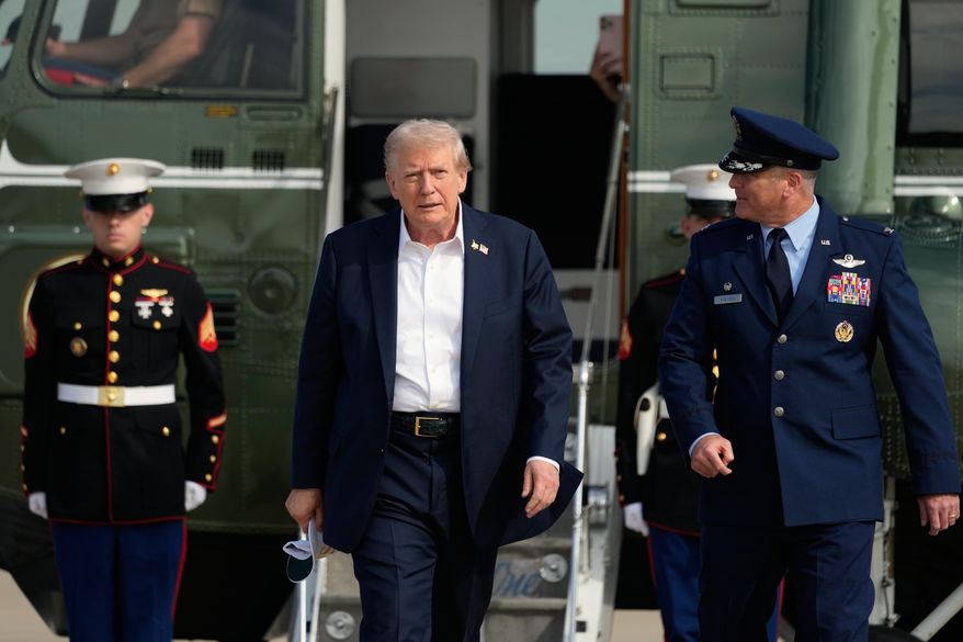 President Donald Trump, center, is escorted by Air Force Col. Christopher M. Robinson, commander of the 89th Airlift Wing, right, as he walks from Marine One to board Air Force One, Friday, Sept. 26, 2025, at Joint Base Andrews, Md. (AP Photo/Alex Brandon)
