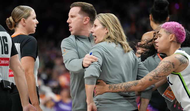 Minnesota Lynx head coach Cheryl Reeve, second from right, yells at officials as she is restrained by Lynx associate head coach Eric Thibault, center, and Lynx guard Natisha Hiedeman, right, after being ejected after earning a second technical foul during the second half of Game 3 of a WNBA basketball playoff semifinals series game against the Phoenix Mercury Friday, Sept. 26, 2025, in Phoenix. (AP Photo/Ross D. Franklin)