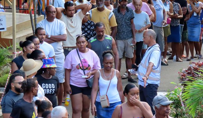 People line up to cast their votes at Beau Vallon Secondary School in Beau Vallon, Seychelles, on Saturday, Sep. 27, 2025. (AP Photo/Emilie Chetty)