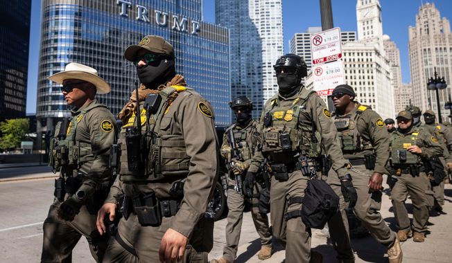 Federal agents from U.S. Immigration and Customs Enforcement and U.S. Customs and Border Protection walk along West Wacker Drive in the Loop, Sunday, Sept. 28, 2025, in Chicago. (Ashlee Rezin/Chicago Sun-Times via AP)