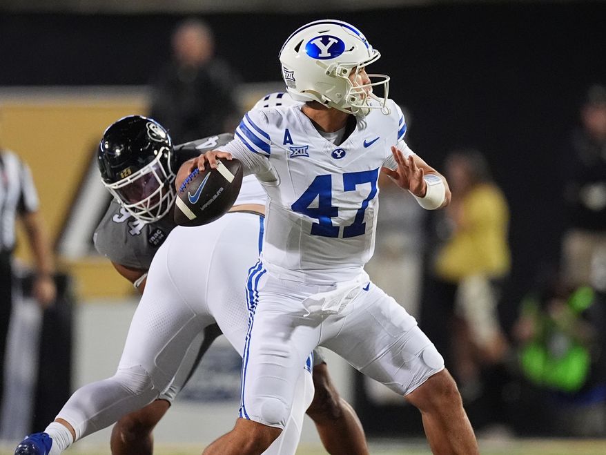Brigham Young quarterback Bear Bachmeier, front, passes the ball as Colorado defensive tackle Tavian Coleman pursues in the first half of an NCAA college football game Saturday, Sept. 27, 2025, in Boulder, Colo. (AP Photo/David Zalubowski)