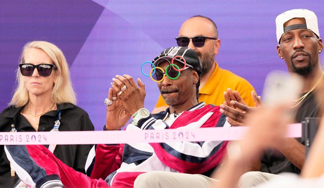 American artist Snoop Dogg, center, sits in the audience prior to the breaking competition at La Concorde Urban Park at the 2024 Summer Olympics, Friday, Aug. 9, 2024, in Paris, France. (AP Photo/Frank Franklin, File)