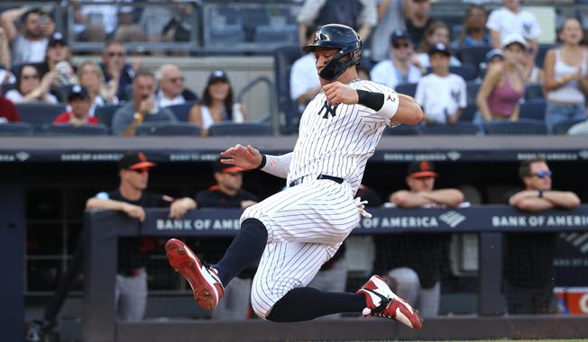 New York Yankees' Aaron Judge slides into home plate to score on a single hit by Giancarlo Stanton during the fourth inning of a baseball game against the Baltimore Orioles, Sunday, Sept. 28, 2025, in New York. (AP Photo/Pamela Smith)