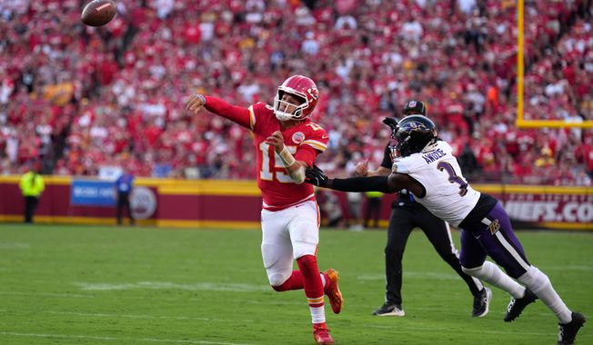 Kansas City Chiefs quarterback Patrick Mahomes (15) throws under pressure from Baltimore Ravens cornerback Chidobe Awuzie (3) during the second half of an NFL football game Sunday, Sept. 28, 2025, in Kansas City, Mo. (AP Photo/Charlie Riedel)