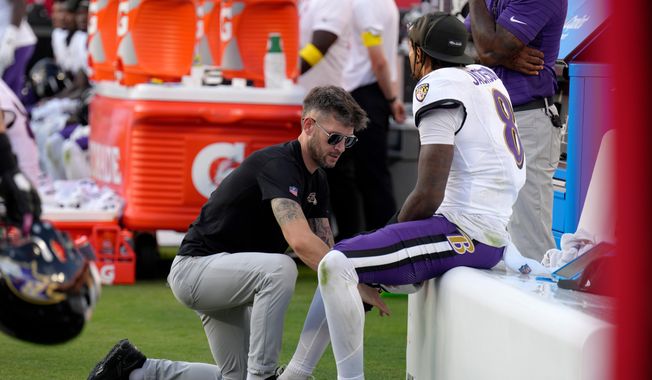 Baltimore Ravens quarterback Lamar Jackson sits on the bench as his leg is worked on during the second half of an NFL football game against the Kansas City Chiefs Sunday, Sept. 28, 2025, in Kansas City, Mo. (AP Photo/Charlie Riedel)