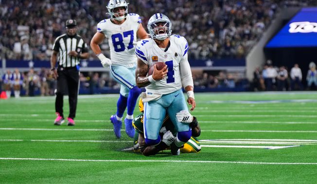 Dallas Cowboys quarterback Dak Prescott (4) is stopped as he carries the ball by Green Bay Packers defensive end Micah Parsons, rear, in overtime of an NFL football game Sunday, Sept. 28, 2025, in Arlington, Texas. (AP Photo/Jeffrey McWhorter)