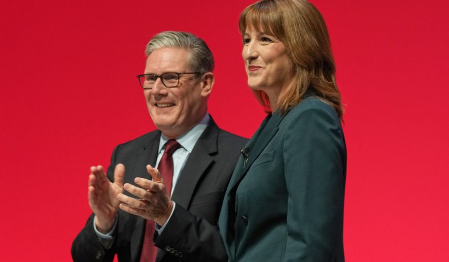 Britain's Chancellor of the Exchequer Rachel Reeves, left, stands next to the Prime Minister Keir Starmer, who applauds after she gave her keynote speech during the annual Labour Party conference in Liverpool, England, Monday, Sept. 29, 2025. (AP Photo/Jon Super)