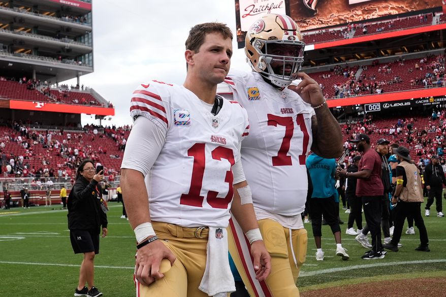 San Francisco 49ers quarterback Brock Purdy (13) and offensive tackle Trent Williams (71) walk off the field after an NFL football game against the Jacksonville Jaguars in Santa Clara, Calif., Sunday, Sept. 28, 2025. (AP Photo/Godofredo A. Vásquez)