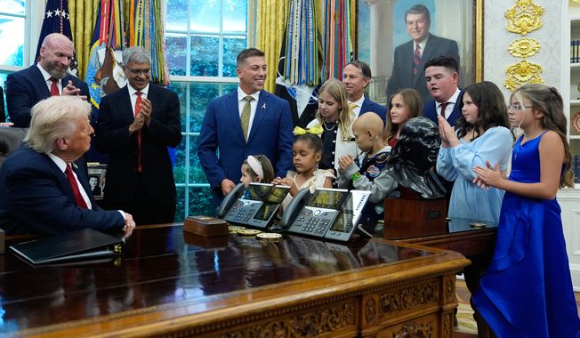 President Donald Trump listens to children who have survived cancer as he speaks in the Oval Office of the White House before signing an executive order regarding childhood cancer and the use of AI, Tuesday, Sept. 30, 2025, in Washington. (AP Photo/Alex Brandon)