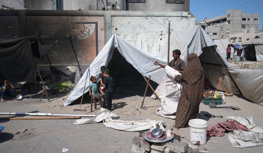 A family sets up a tent near a UN school used as a shelter for displaced Palestinians in Khan Younis, Tuesday, Sept 30, 2025. (AP Photo/Jehad Alshrafi)