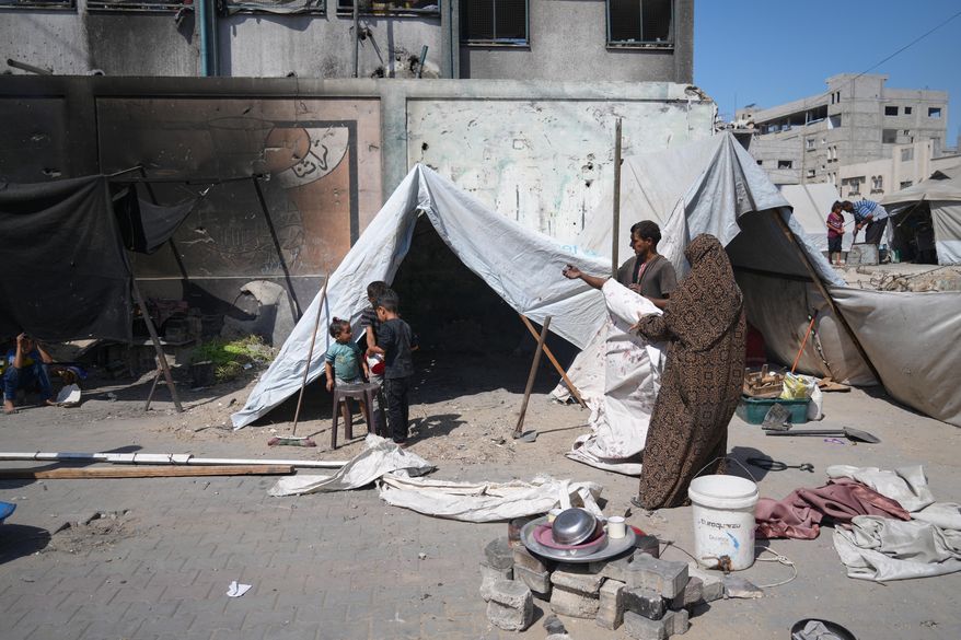 A family sets up a tent near a UN school used as a shelter for displaced Palestinians in Khan Younis, Tuesday, Sept 30, 2025. (AP Photo/Jehad Alshrafi)