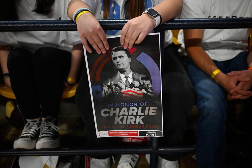 An attendee holds a poster of Charlie Kirk at a Turning Point USA rally at Utah State University, as a part of the organization's push to memorialize Kirk, Tuesday, Sept. 30, 2025, in Logan, Utah. (AP Photo/Alex Goodlett)