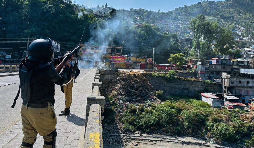 CORRECTS HAME: Police officers fire tear gas shell to disperse members of the Awami Action Committee, a civil rights alliance holding a rally demanding subsidized food, electricity and other services, in Muzaffarabad, the capital of Pakistani controlled Kashmir, Tuesday, Sept. 30, 2025. (AP Photo/M.D. Mughal)