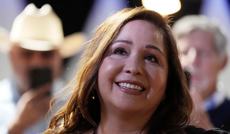 Arizona Democratic candidate Adelita Grijalva listens to her children speak at the stage podium after being declared the winner against Republican Daniel Butierez, to fill the Congressional District 7 seat held by the late U.S. Rep. Raúl Grijalva in a special election Tuesday, Sept. 23, 2025, in Tucson, Ariz. (AP Photo/Ross D. Franklin)