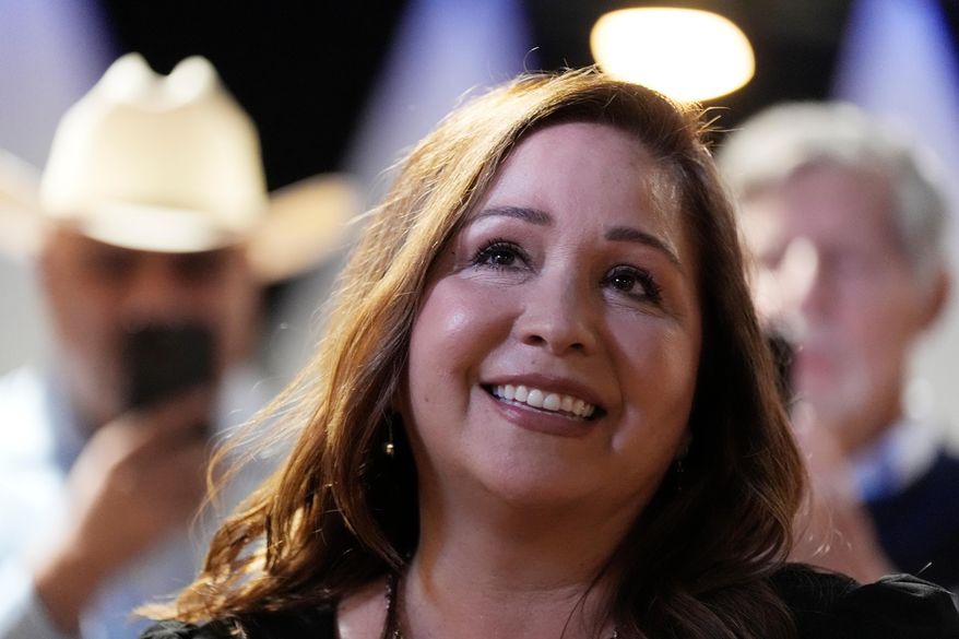 Arizona Democratic candidate Adelita Grijalva listens to her children speak at the stage podium after being declared the winner against Republican Daniel Butierez, to fill the Congressional District 7 seat held by the late U.S. Rep. Raúl Grijalva in a special election Tuesday, Sept. 23, 2025, in Tucson, Ariz. (AP Photo/Ross D. Franklin)