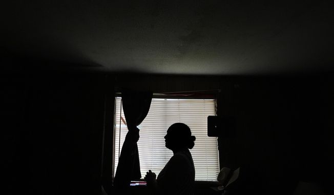 Paola Freites, who asked to be identified by her middle name and second last name to protect her family's safety, stands inside the two-bedroom mobile home where she lives with her husband and three children after fleeing persecution in their native Colombia, Thursday, Aug. 21, 2025, in Apopka, Fla. (AP Photo/Rebecca Blackwell)