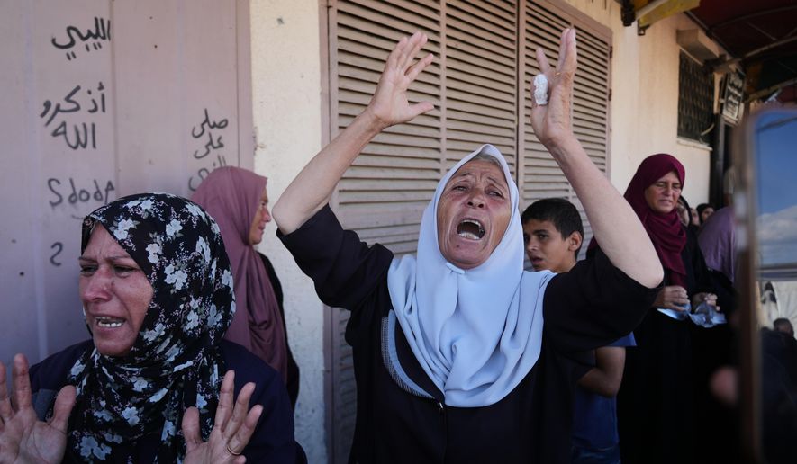 Palestinians mourn during the funeral of their relatives who were killed in an Israeli airstrike on Deir al-Balah, central Gaza Strip, Wednesday, Oct. 1, 2025. (AP Photo/Abdel Kareem Hana)