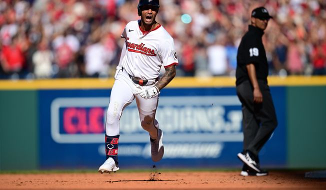 Cleveland Guardians Brayan Rocchio reacts as he rounds the bases after hitting a solo home run in the eighth inning of Game 2 of the American League Wild Card baseball playoff series against the Detroit Tigers in Cleveland, Wednesday, Oct. 1, 2025. Umpire Vic Carapazza looks on at right. (AP Photo/David Dermer)