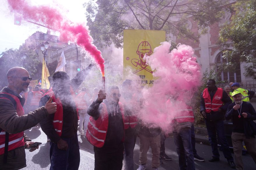 Unionists use flares during a new round of strikes and protests against the caretaker government and cost-cutting Thursday, Oct. 2, 2025 in Paris. (AP Photo/Michel Euler)