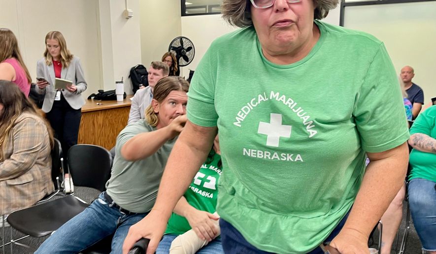 Lia Post, of Springfield, Neb., leaves a meeting of the Nebraska Medical Cannabis Commission, where she sobbed and begged its members to honor the will of the voters in approving comprehensive access to medical marijuana, Tuesday, Sept. 30, 2025 in Lincoln, Neb. (AP Photo/Margery Beck)