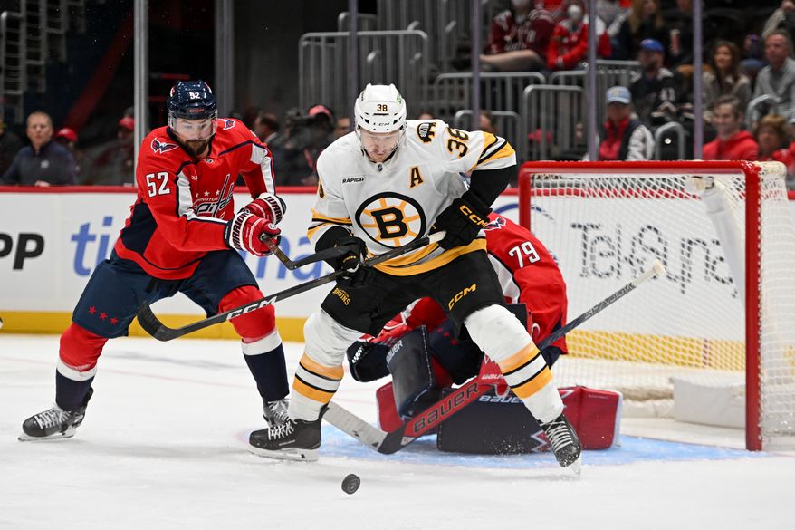 Boston Bruins forward Patrick Brown (38) fighting for the puck with Washington Capitals defenseman Dylan McIlrath (52) during the first period of a preseason NHL game at Capital One Arena in Washington D.C., October 2, 2025. (Photo for the Washington Times)