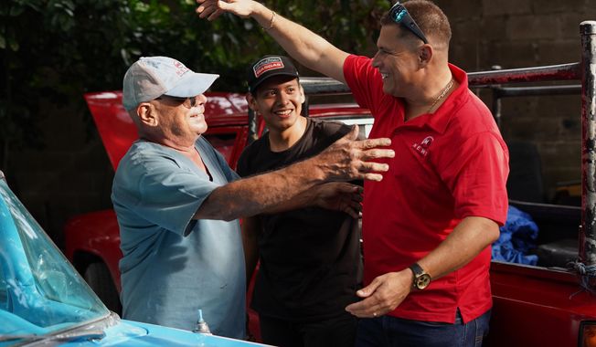 Salvadoran journalist Mario Guevara, right, greets neighbors after arriving at a relative's home in Apopa, El Salvador, following his deportation from the United States, Friday, Oct. 3, 2025. (AP Photo/Salvador Melendez)