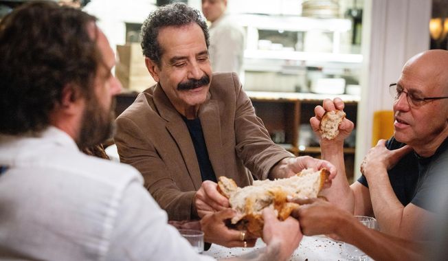 This image released by CNN shows Tony Shalhoub, center, in a scene from his series "Breaking Bread," which follows the actor across the globe as he explores cultures and food through the lens of bread. (CNN via AP)