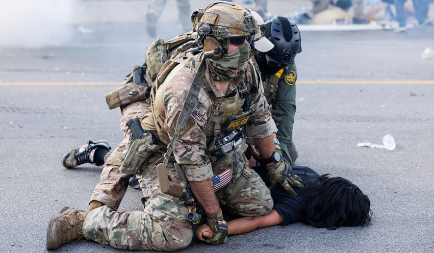 Federal officers hold down a protester in the Brighton Park neighborhood of Chicago, on Saturday, Oct. 4, 2025, after protesters learned that U.S. Border Patrol shot a woman Saturday morning on Chicago's Southwest Side. (Anthony Vazquez/Chicago Sun-Times via AP)