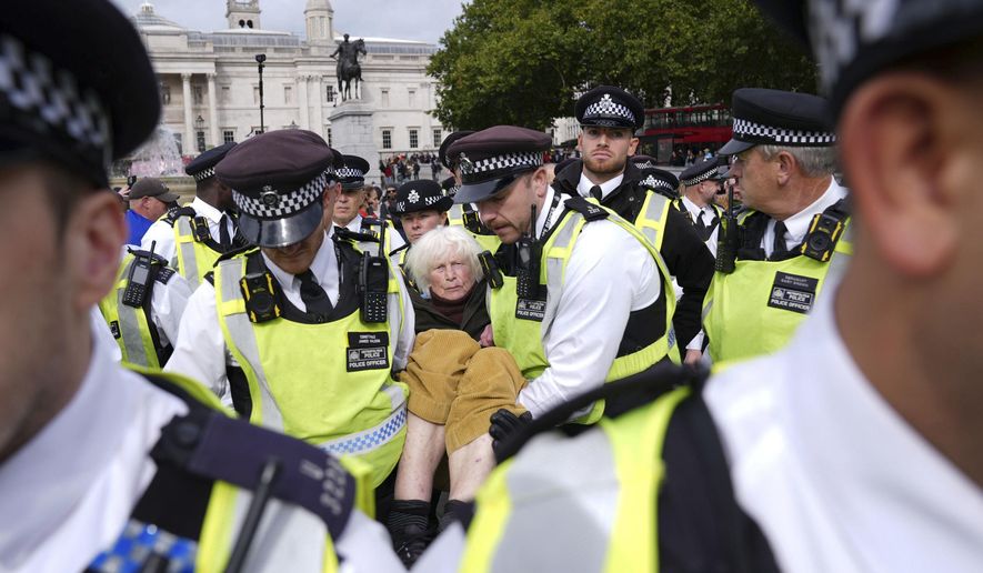 Police remove a protester taking part in a demonstration organised by Defend our Juries, in support of Palestine Action in Trafalgar Square, London Saturday Oct. 4, 2025. (Maja Smiejkowska/PA via AP)