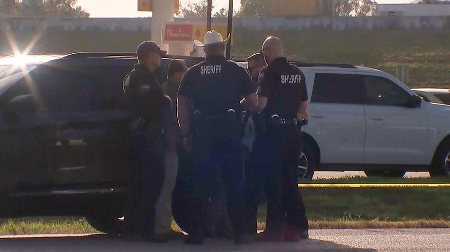 Law enforcement officials investigate a vehicle near the scene of a deadly shooting shooting early Saturday, Oct. 4, 2025 in the Houston suburb of Angleton, Texas. (KTRK via AP)