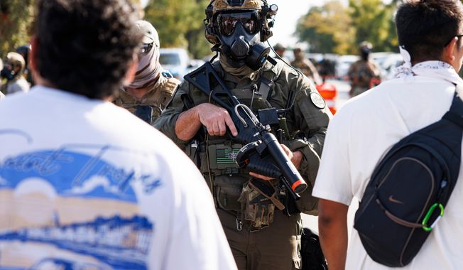 Federal officers stand guard in the Brighton Park neighborhood of Chicago, on Saturday, Oct. 4, 2025, after protesters learned that U.S. Border Patrol shot a woman Saturday morning on Chicago's Southwest Side. (Anthony Vazquez/Chicago Sun-Times via AP)