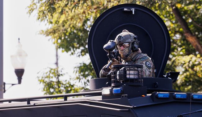A federal officer stands guard in the Brighton Park neighborhood of Chicago, on Saturday, Oct. 4, 2025, after protesters learned that U.S. Border Patrol shot a woman Saturday morning on Chicago's Southwest Side. (Anthony Vazquez/Chicago Sun-Times via AP)
