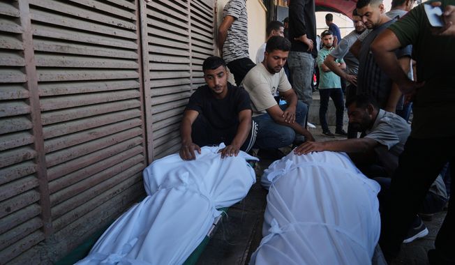 Mourners attend the funeral of Palestinians killed in an Israeli army strike, outside Al-Aqsa Hospital in Deir al-Balah, central Gaza Strip, Saturday, Oct. 4, 2025. (AP Photo/Abdel Kareem Hana)