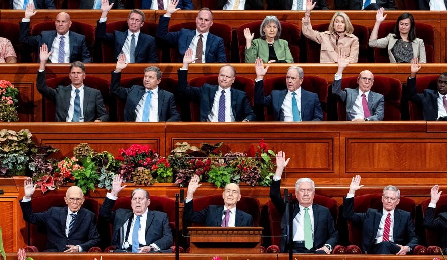 Elder Henry B. Eyring, bottom center, of the Quorum of the Twelve Apostles, and other Church leaders raise their hands as part of a sustaining vote during the morning session of the 195th Semiannual General Conference of The Church of Jesus Christ of Latter-day Saints at the Conference Center in Salt Lake City on Saturday, Oct. 4, 2025. (Isaac Hale/The Deseret News via AP)