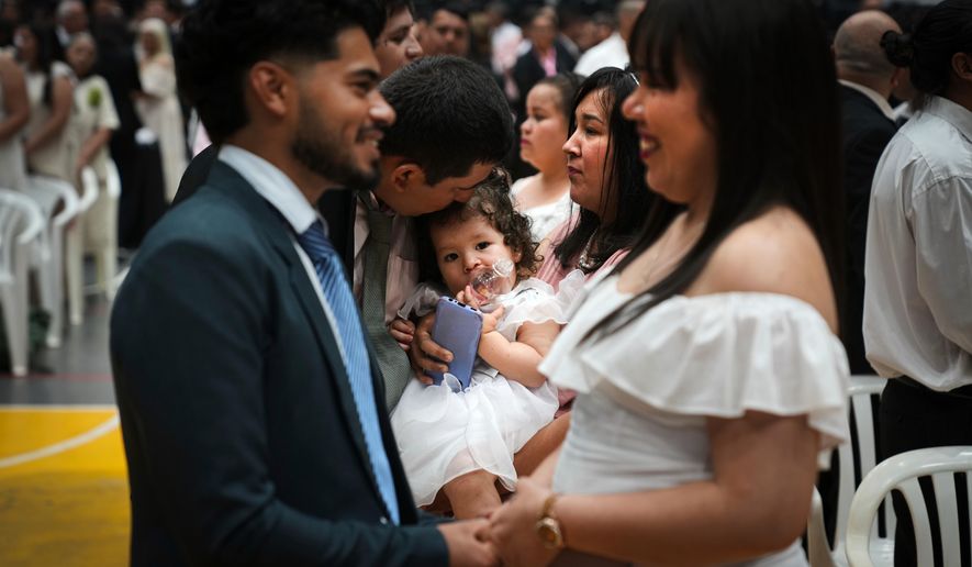 Couples attend a group ceremony organized by the Civil Registry to legally formalize their unions in in Asuncion, Paraguay, Saturday, Oct. 4, 2025. (AP Photo/Jorge Saenz)