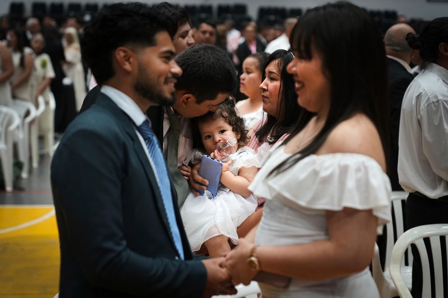 Couples attend a group ceremony organized by the Civil Registry to legally formalize their unions in in Asuncion, Paraguay, Saturday, Oct. 4, 2025. (AP Photo/Jorge Saenz)