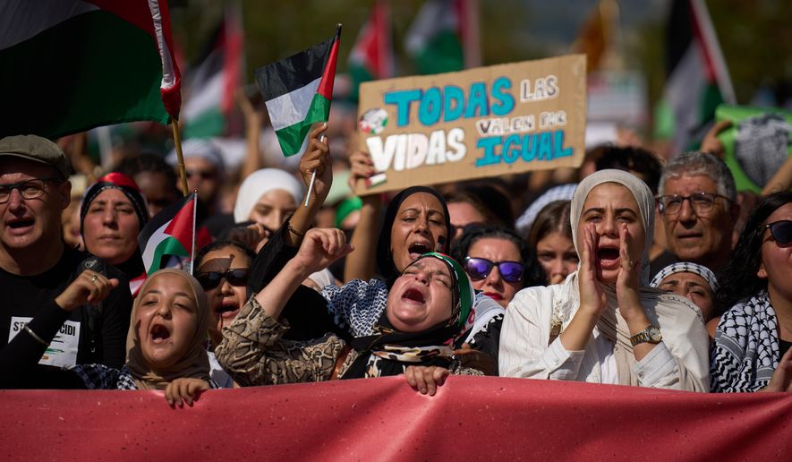 Demonstrators shout slogans as they march during a pro-Palestinian rally in solidarity with the Global Sumud Flotilla after ships were intercepted by the Israeli navy, in Barcelona, Spain, Saturday, Oct. 4, 2025. (AP Photo/Emilio Morenatti)