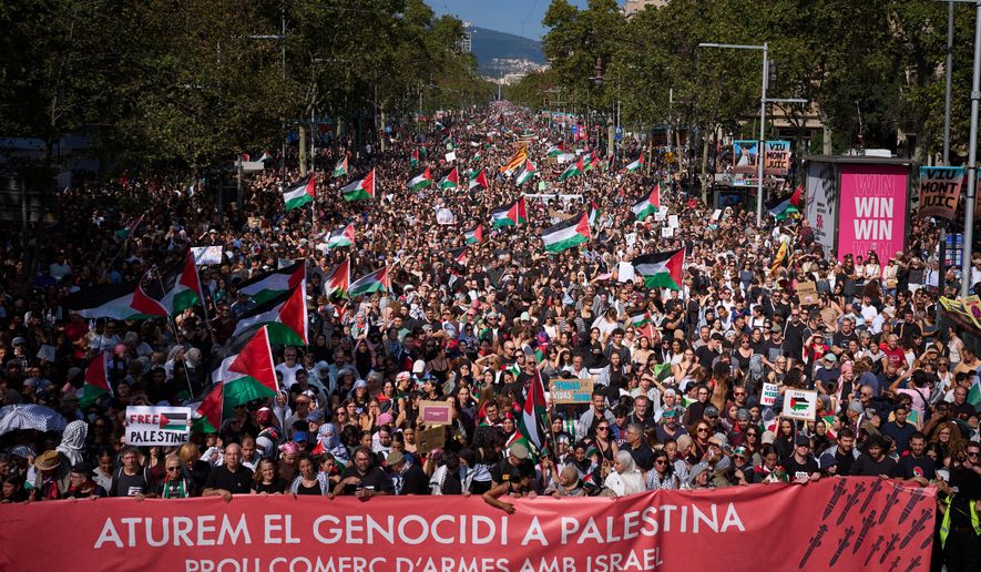 Demonstrators hold a banner with writing reading in Catalan "Let’s stop the genocide in Palestine, no more arms trade with Israel”" during a pro-Palestinian rally in solidarity with the Global Sumud Flotilla after ships were intercepted by the Israeli navy, in Barcelona, Spain, Saturday, Oct. 4, 2025. (AP Photo/Emilio Morenatti)