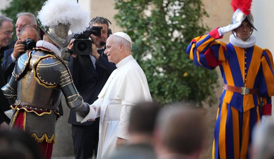 Pope Leo XIV is greeted by Pontifical Swiss Guard's 35th Commander Christoph Graf, left, upon his arrival to the swearing in ceremony of 27 Pontifical Swiss Guards cadets in the St. Damasus courtyard at the Vatican, Saturday, Oct. 4, 2025. (AP Photo/Andrew Medichini)